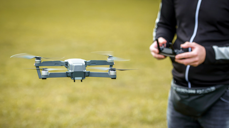 A man operating a drone with a remote control