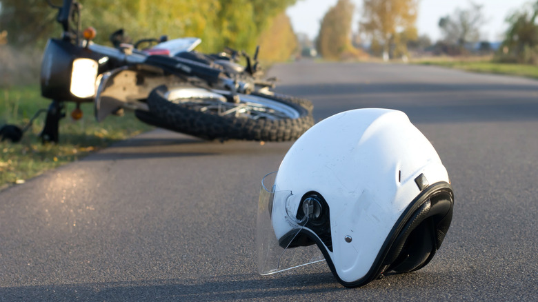 Motorcycle and helmet fallen down on road