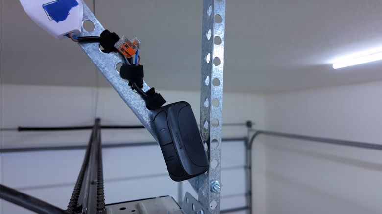 Man's DIY smart garage door solution attached above garage door motor