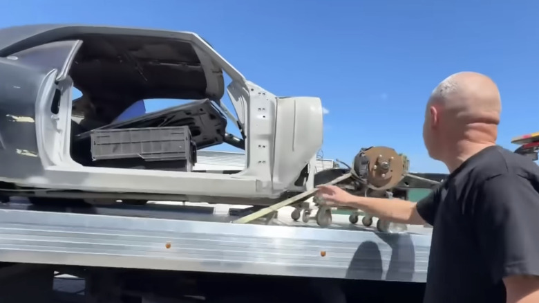 Victor Munoz stands next to his recovered Camaro which has been loaded onto a flatbed