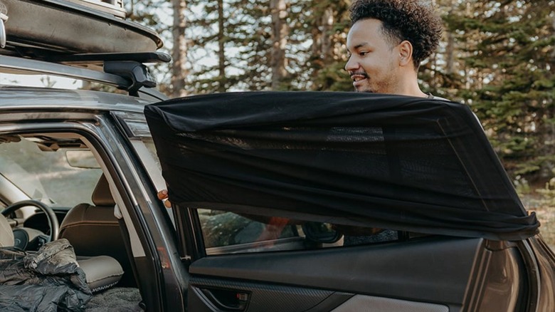 Man putting screen on car window