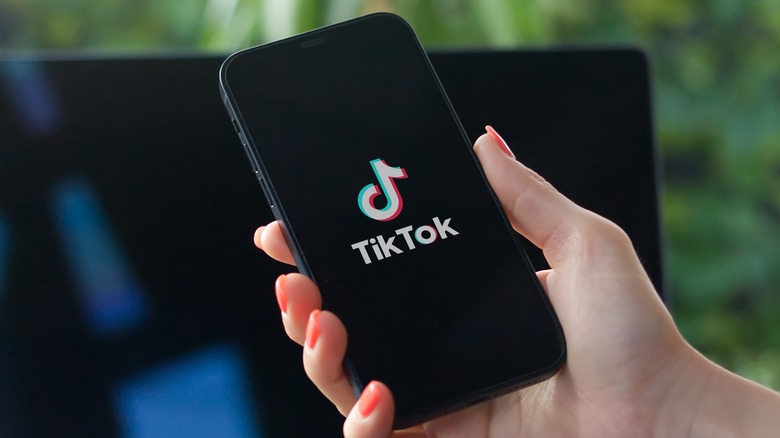 woman using tiktok on smartphone