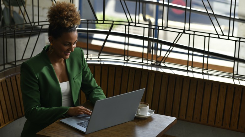 Woman using laptop in cafe