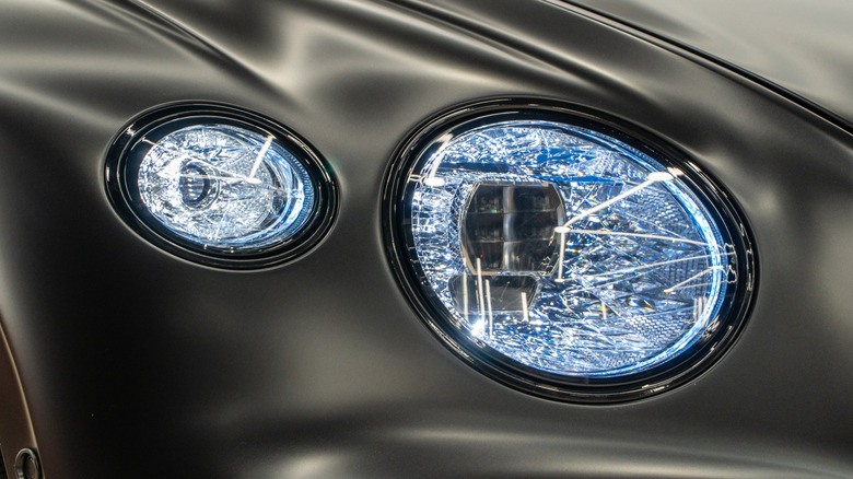 A close-up of a black Bentley Continental GT crystal headlight housing.