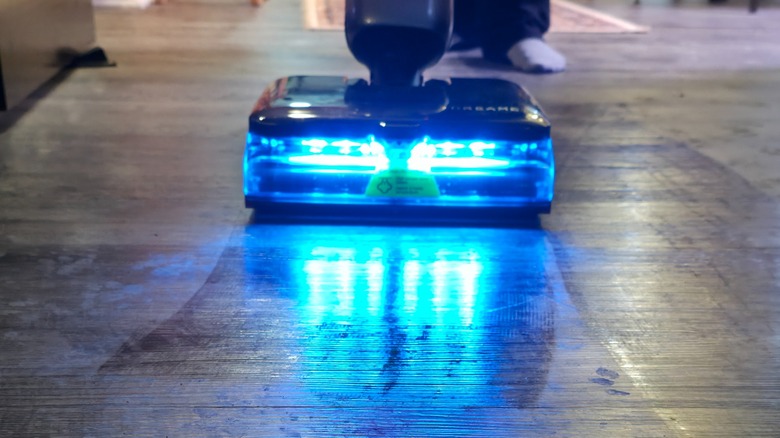 A person using the Aero Ultra Steam of dark flooring