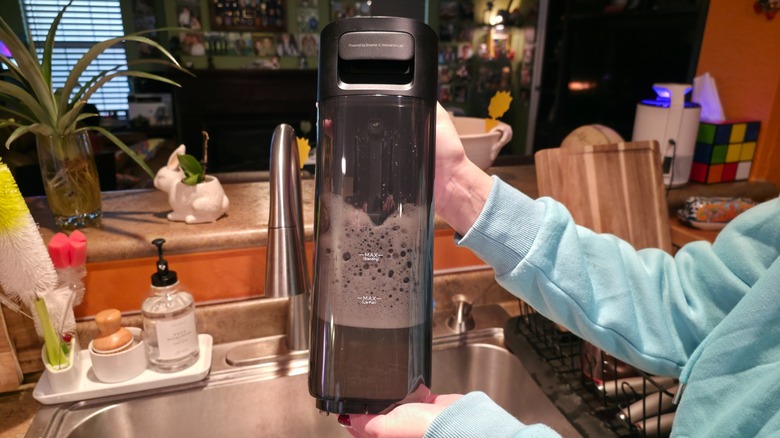 A person holding the dirty water tank from the Aero Ultra Steam