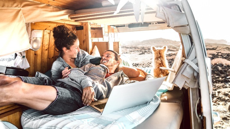 A couple laying in bed in a camper van