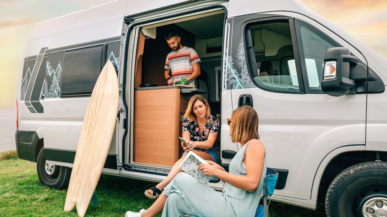 People hanging out with camper van