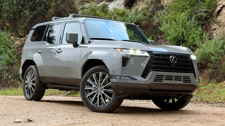 Lexus GX parked in the dirt with a cliff in the background