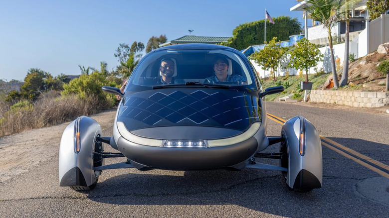 A driver and a passenger smiling in an Aptera car