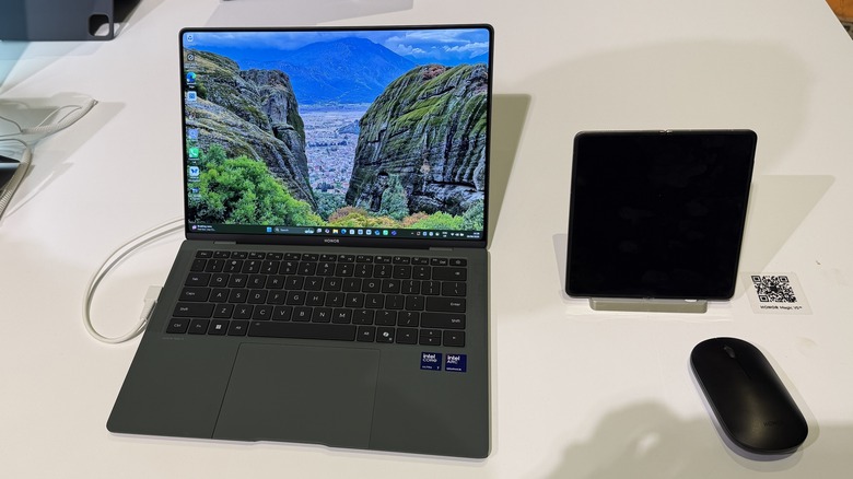 Honor laptop and phone on a table with a mouse