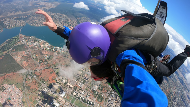 Handheld photo of a skydiver with the ground visible in the distance