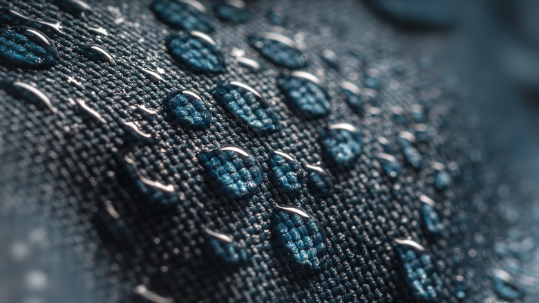 Water drops beading up and running off material