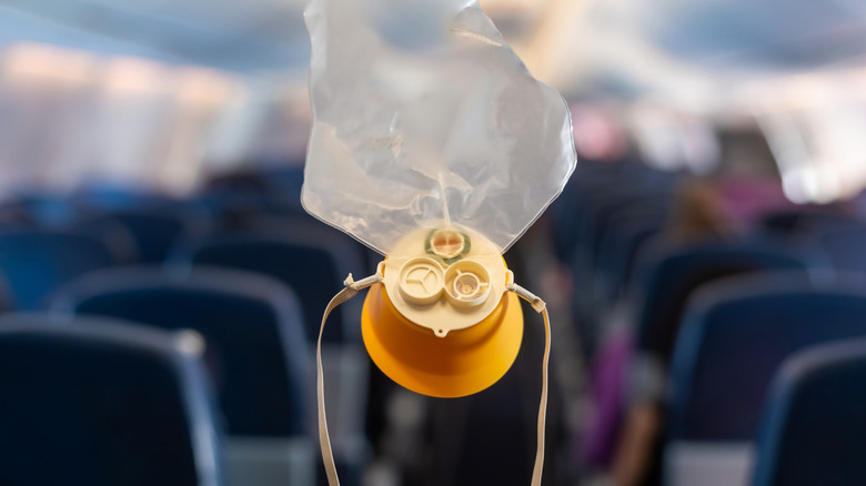 Airplane oxygen mask held in front of the cabin.
