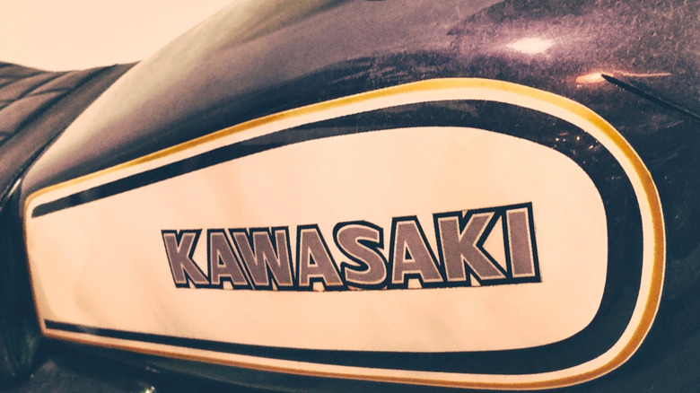 Close-up of old Kawasaki logo on fuel tank in sepia