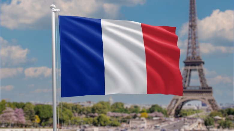 A French Flag Waving With Eiffel Tower In Background