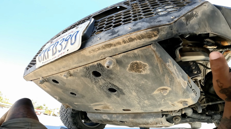 A GX460 SUV with a worn out skid plate underneath