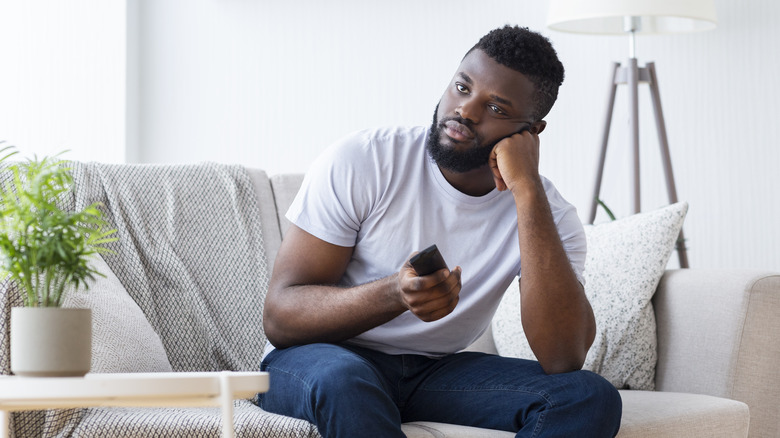 man using television remote control