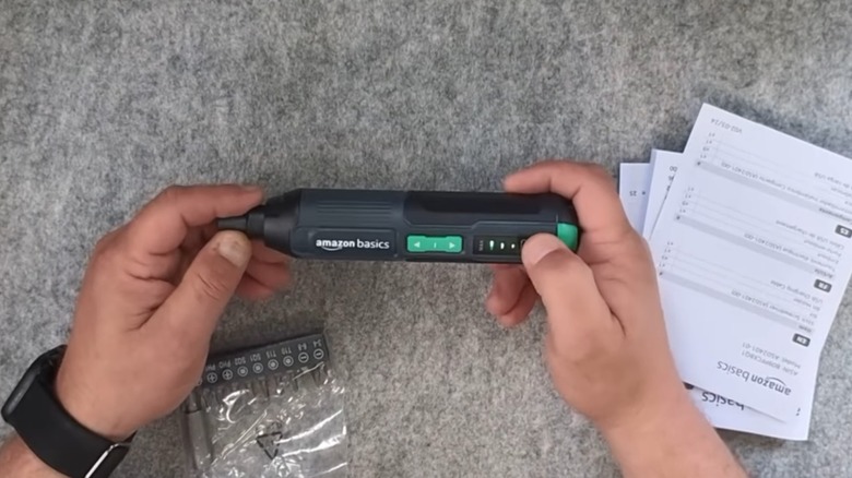 a person holding an amazon basics cordless 4-volt screwdriver
