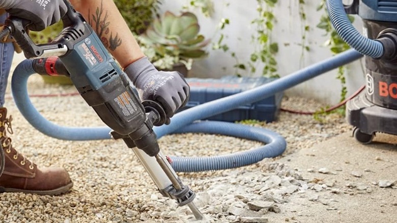 Person using Bosch Concrete/Masonry Rotary Hammer Drill on concrete