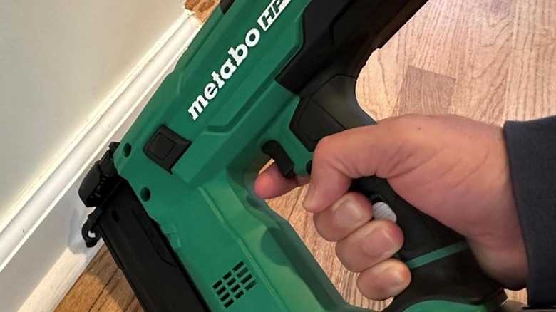Person using Metabo HPT 18V MultiVolt Compact 18 Gauge Brad Nailer on trim