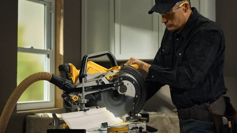 Person cutting molding with a DeWalt 20V Max XR 10-inch Double Bevel Fixed Miter Saw