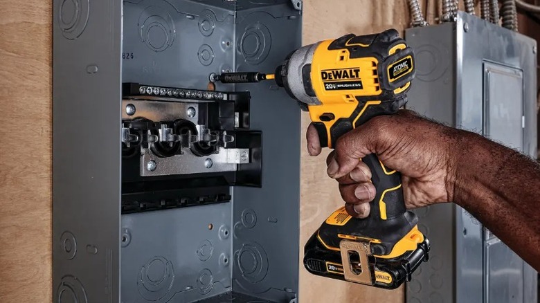 Person attaching scre in electric box with DeWalt Atomic 20V Max Impact Driver