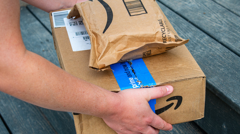 Amazon delivery worker places Amazon Prime packages on the doorstep of a residence