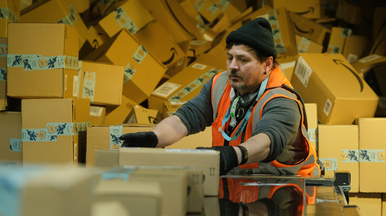 Worker loading Amazon packages on delivery truck
