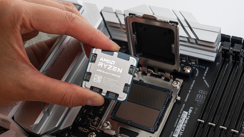 PC builder planting a Ryzen 9 7950XD CPU in an X670-E motherboard.