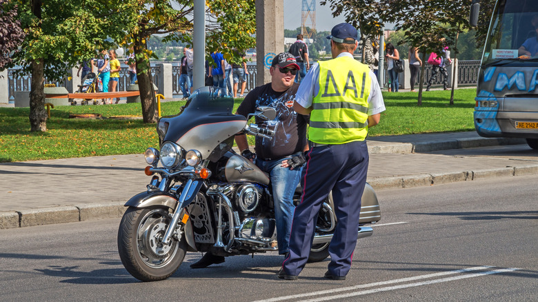 A motorcyclist being stopped by a police in a high-vis vest