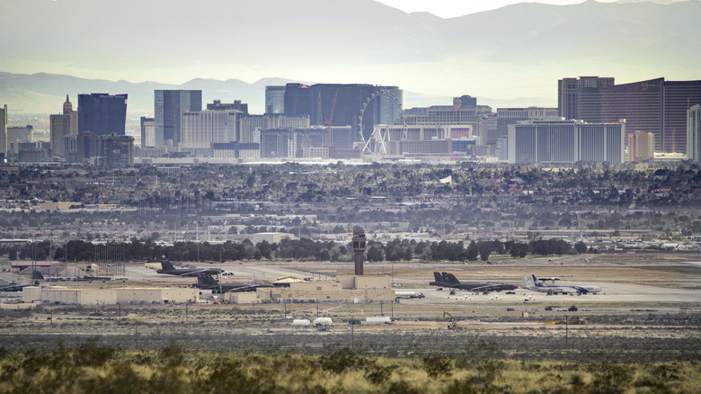 Planes on the tarmac of Nellis AFB with Las Vegas seen in the background.