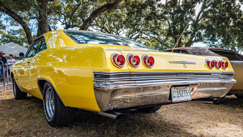 Rear 3/4 view of 1965 Chevrolet Impala in car show setting