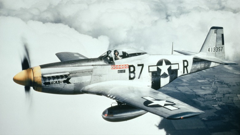 A P-51D-5NA Mustang flying over cloudy skies