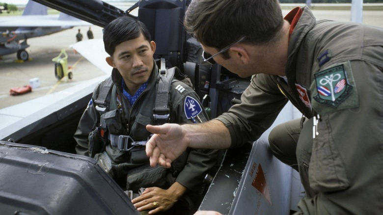 A life support officer explains the ejection seat to a Thai pilot in an F-15 Eagle