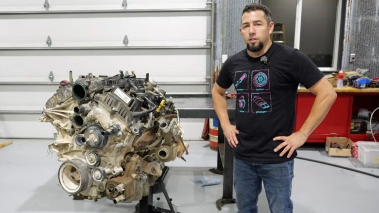 Eric, the owner of Importapart and I Do Cars YouTube channel host, posing next to a failed Ford F-150 engine.