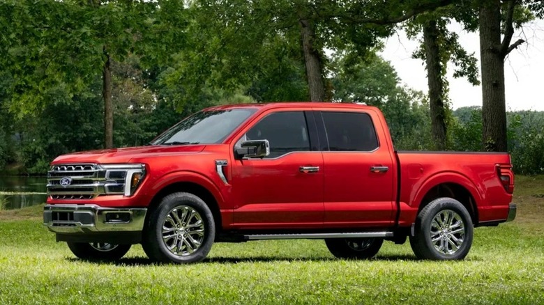 A red 2027 Ford F-150 in a park-like setting.