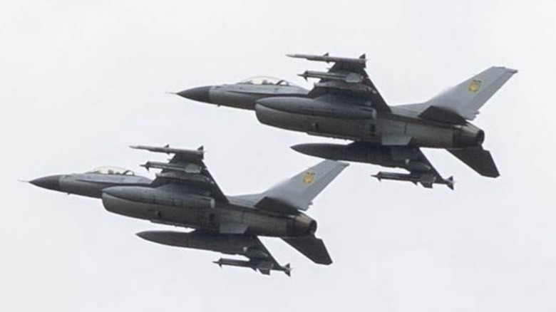 Two Ukrainian Air Force F-16 Fighting Falcons flying in formation over grey skies.