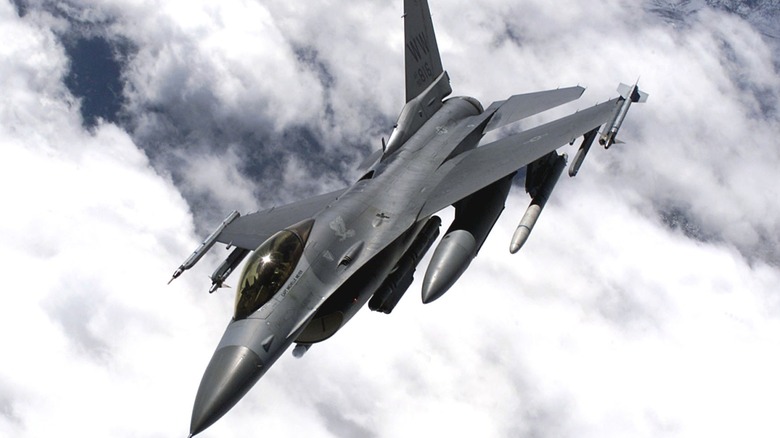 An F-16 flying over cloudy skies