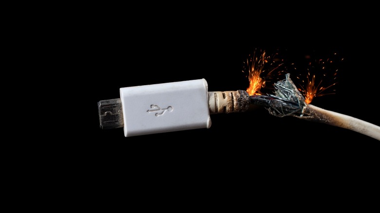 USB cord on black background catching on fire