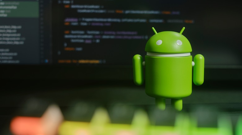 Android robot in front of a laptop.