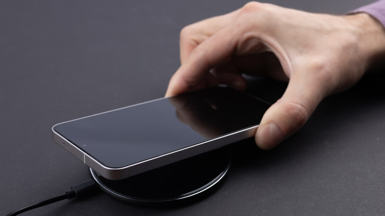 An iPhone being placed on a wireless charger