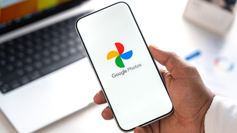 Google Photos logo is displayed on the screen of a smartphone