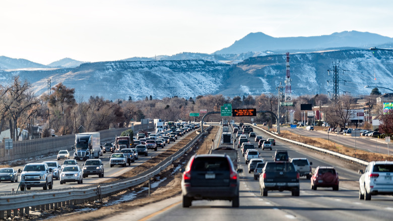 Wide view of a busy Colorado highway, with mountains in the distance.