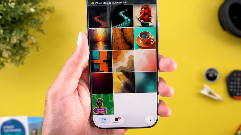 iPhone in hand showing iOS 26 Photos app