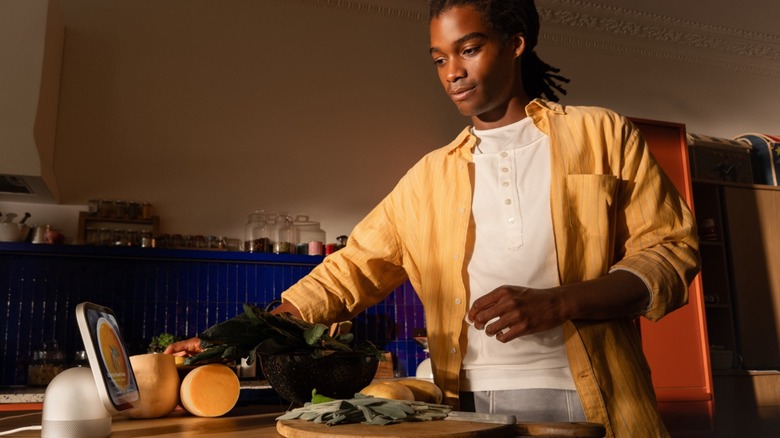 Man follows recipe in kitchen on Apple HomeView device.