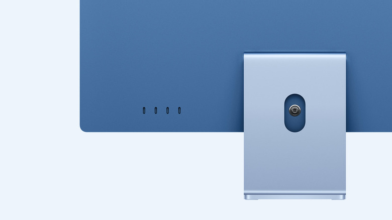 Four Thunderbolt ports on the back of an iMac, pale background