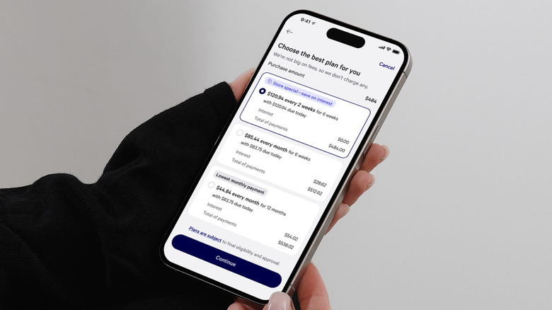 A person holding a cell phone and selecting an Affirm payment plan