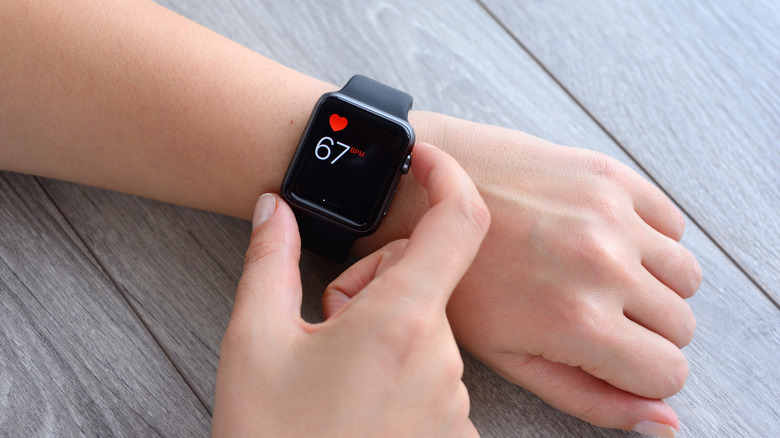 Woman checking heat rate on smartwatch