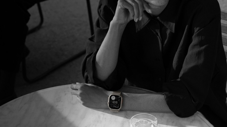 Woman sitting in table wearing Apple Watch Ultra 3